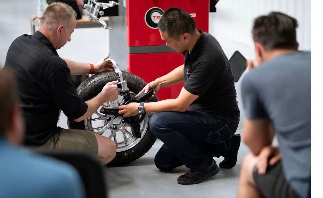 Przemek Popławski and Yan Zhu demonstrating a QC20 tire clamp during distributor training in Sulejówek, Poland